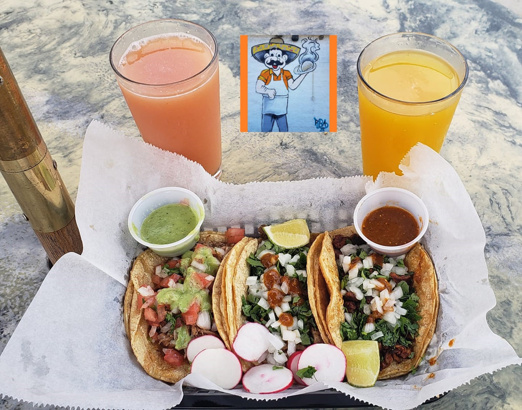 3 Tacos on table outdoors with 2 beverages